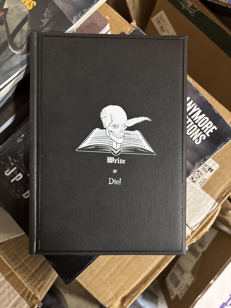 A black notebooks with "Write or Die" on it.